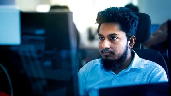 Man working on a computer in an office setting.