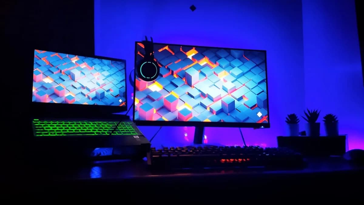 two computer monitors sitting on top of a desk