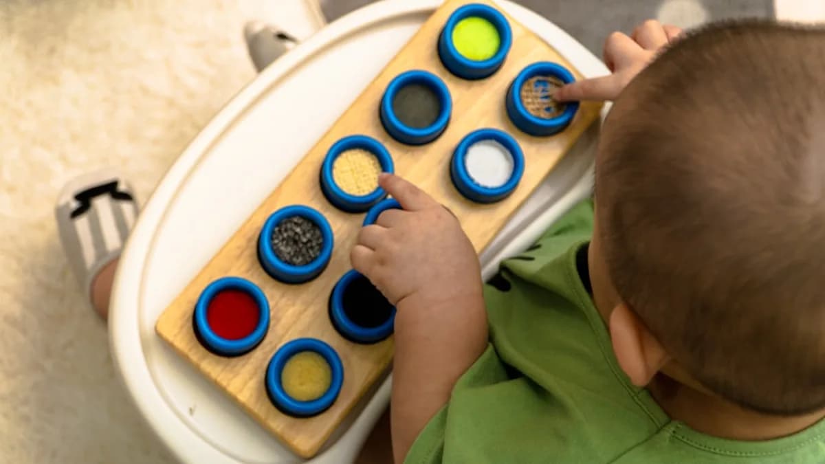 boy in green t-shirt playing with blue and white round plastic toy