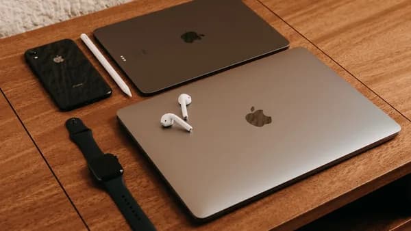 silver macbook beside black apple watch