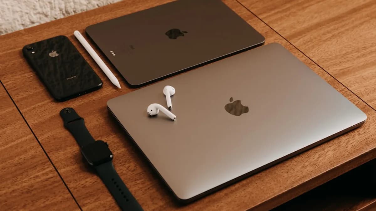 silver macbook beside black apple watch