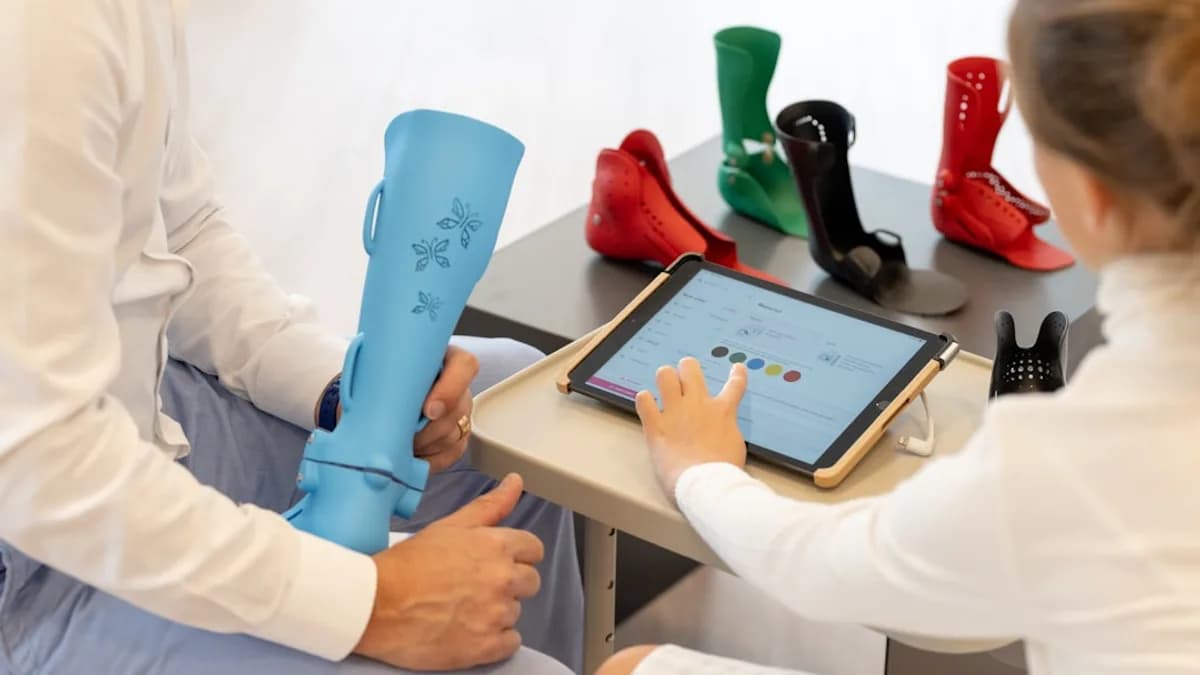 a man and a woman sitting on a table with a tablet