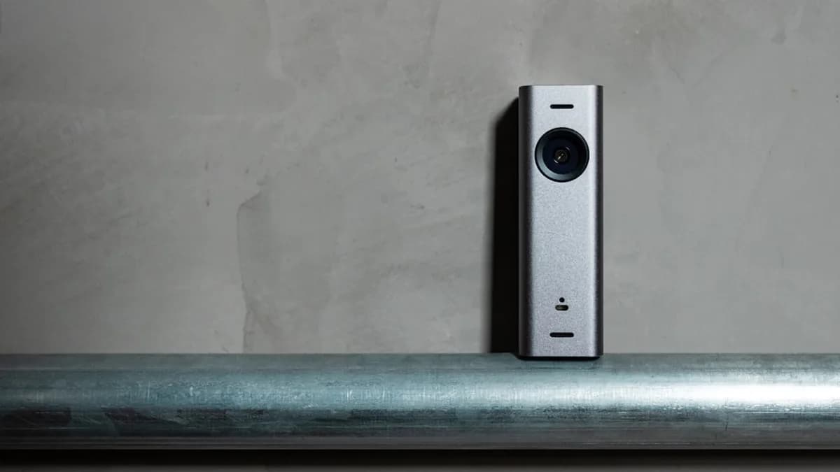 a silver camera sitting on top of a metal pole
