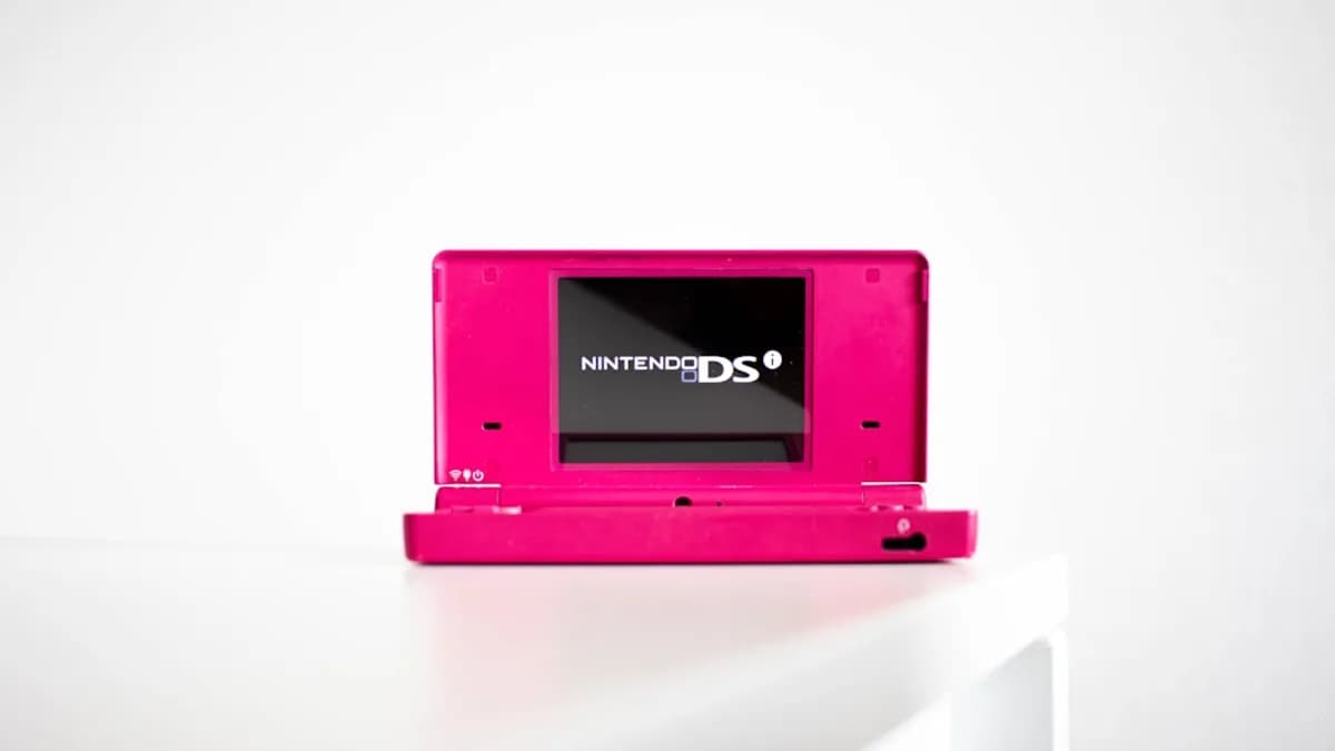 a pink nintendo ds sitting on top of a white table
