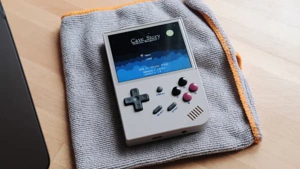 a nintendo game boy sitting on top of a blanket