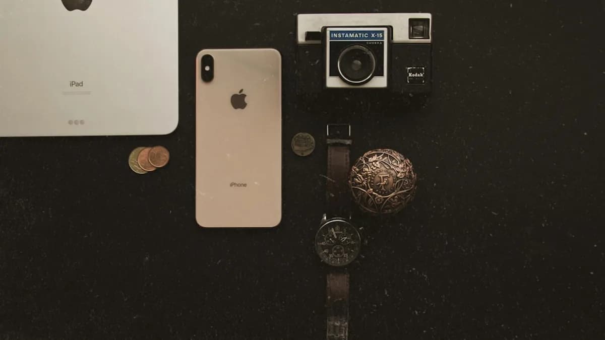 an iphone, watch, and other items on a table