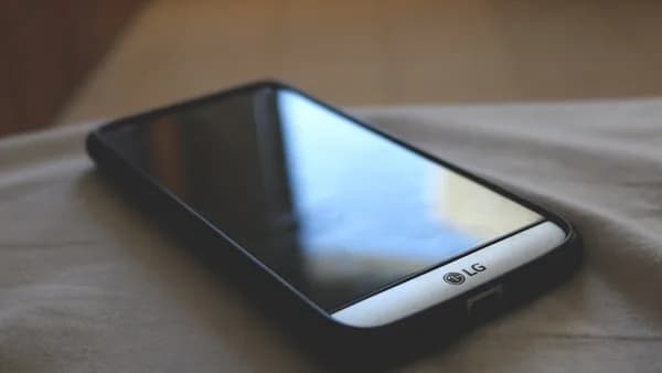 grey LG Android smartphone with black smartphone case on grey textile