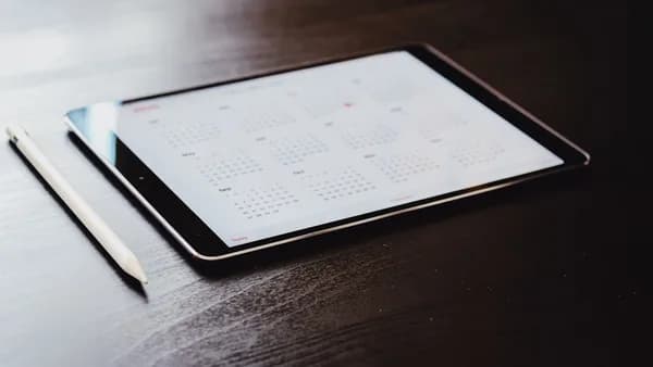 white ipad on brown wooden table