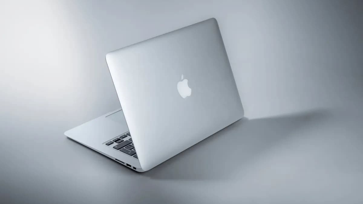 silver macbook on white table