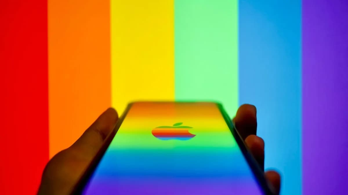 a person holding an iphone in front of a rainbow background