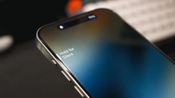 a close up of a cell phone with a keyboard in the background