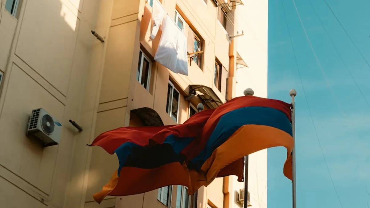 a flag flying in the wind next to a tall building