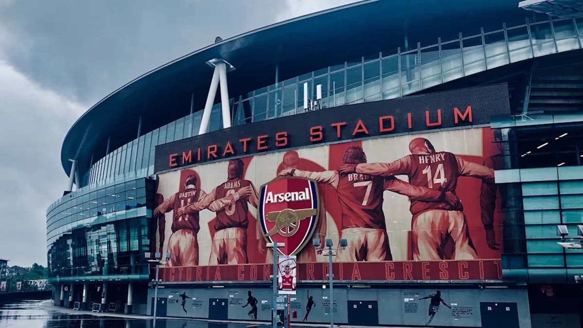 a man standing in front of the emirates stadium