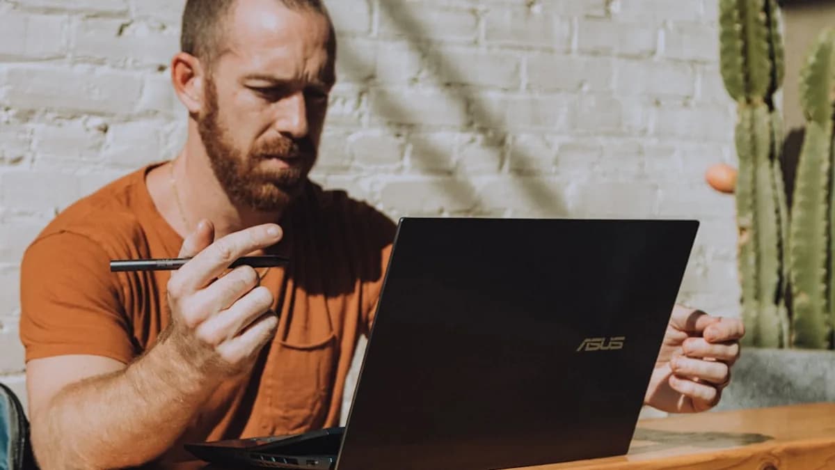 a man sitting at a table using a laptop computer
