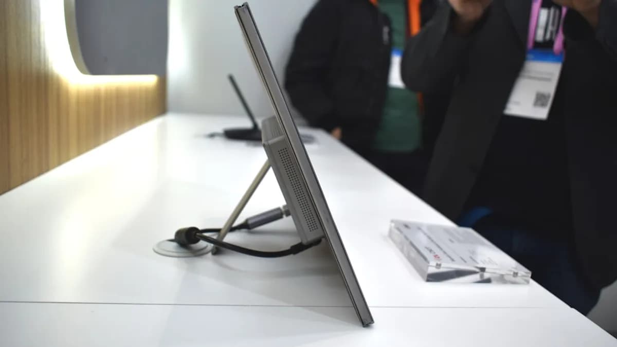 A slim monitor stands on a white surface.