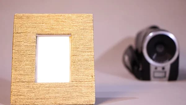 Wooden picture frame with a camcorder in background