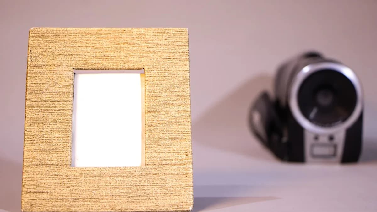 Wooden picture frame with a camcorder in background