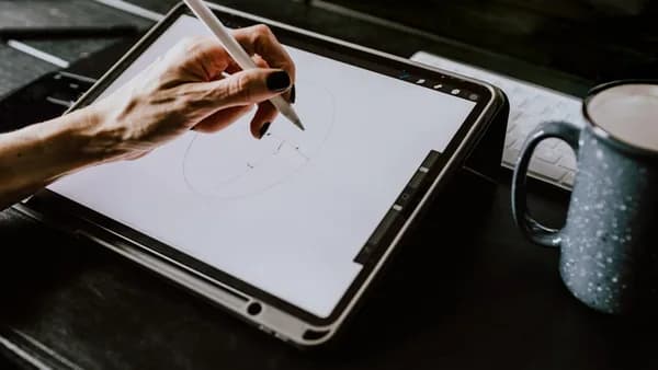 person holding white ipad with black case