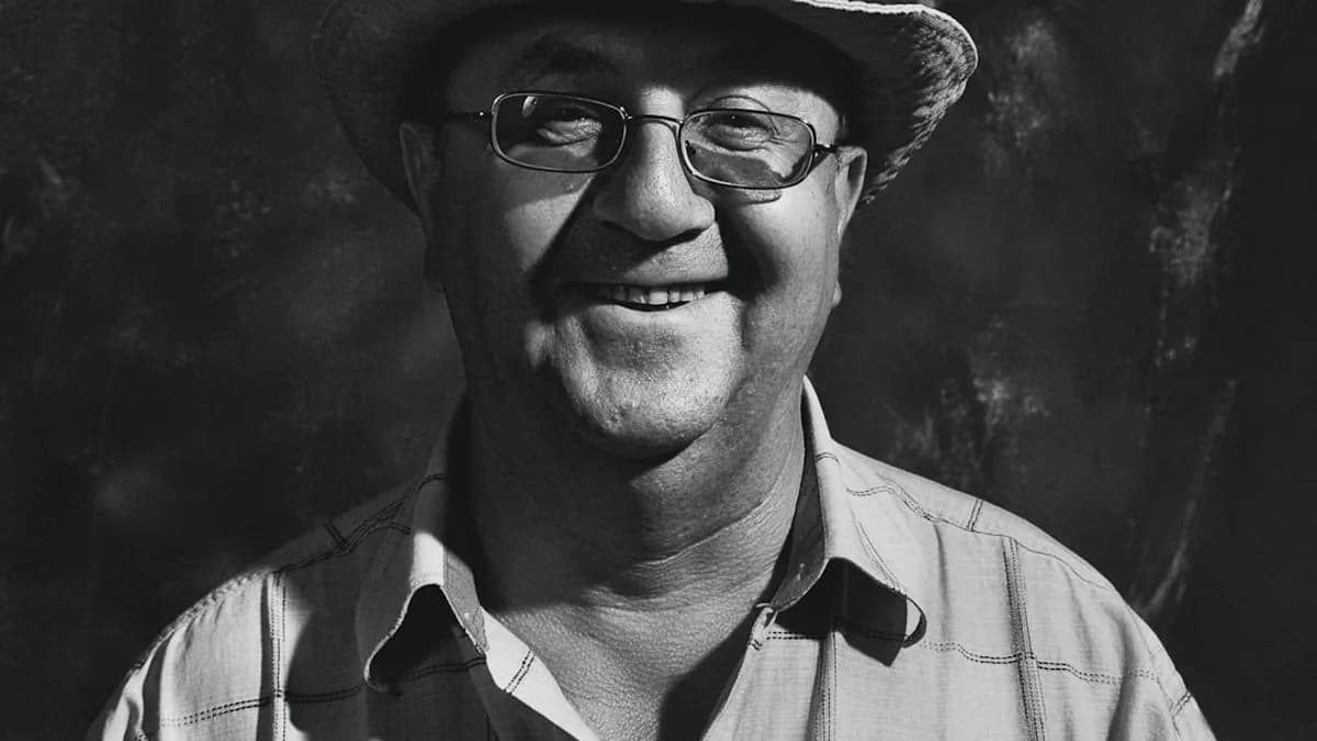 grayscale photo of man wearing hat and button up shirt