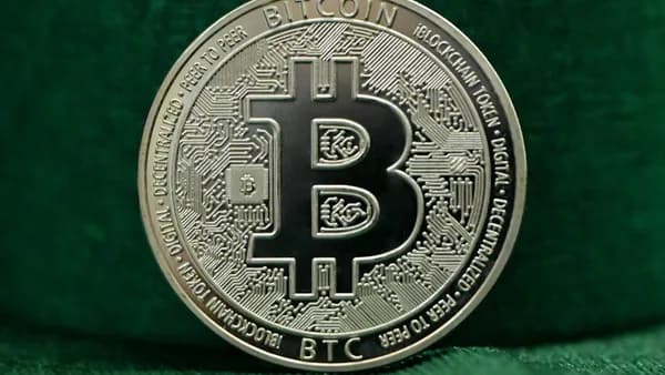 a bit coin sitting on top of a green cloth