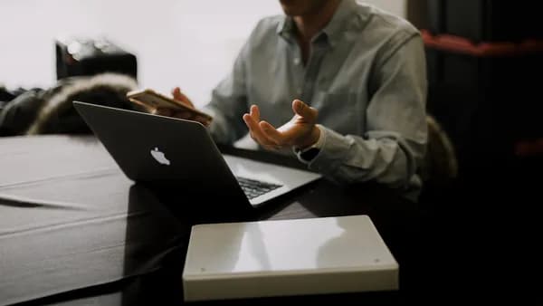 a man sitting at a table with a laptop in front of him