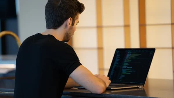 man in black t-shirt using laptop computer