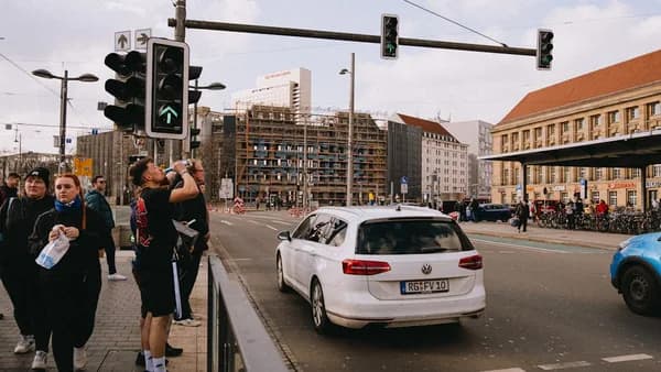 People wait at a traffic light in a city.