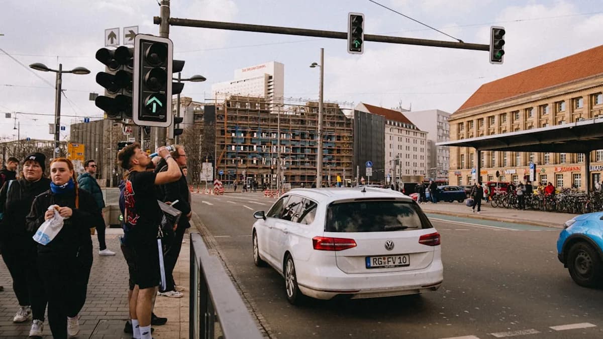 People wait at a traffic light in a city.