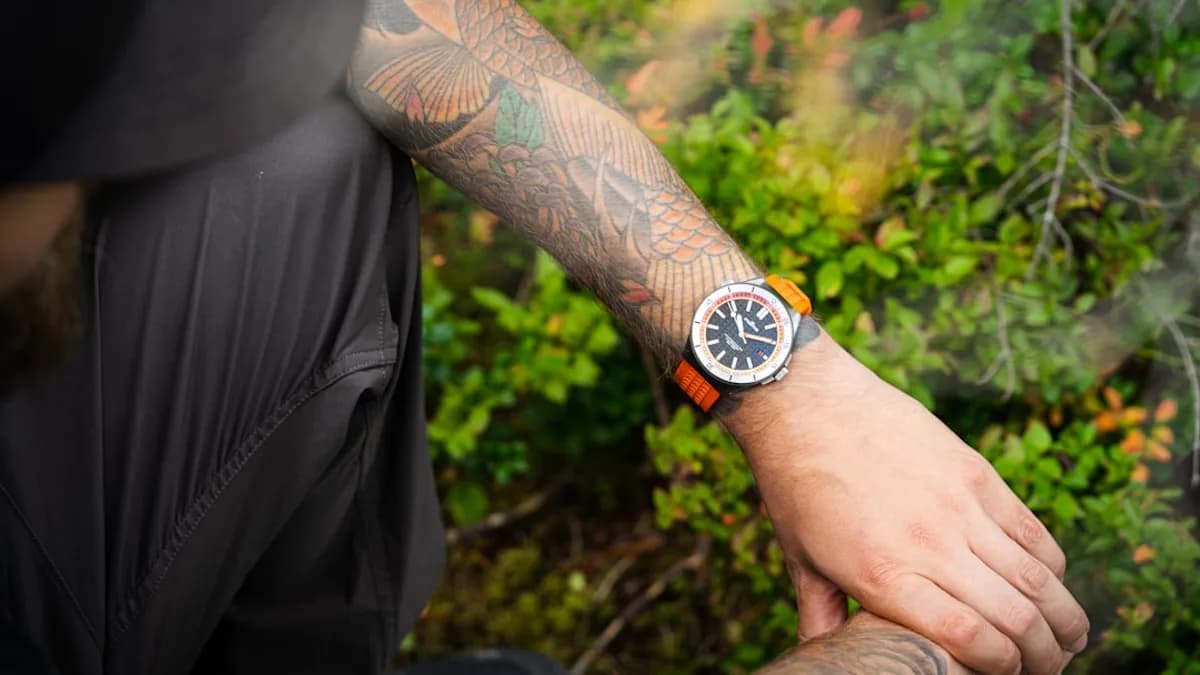 a man with a tattoo on his arm holding a watch