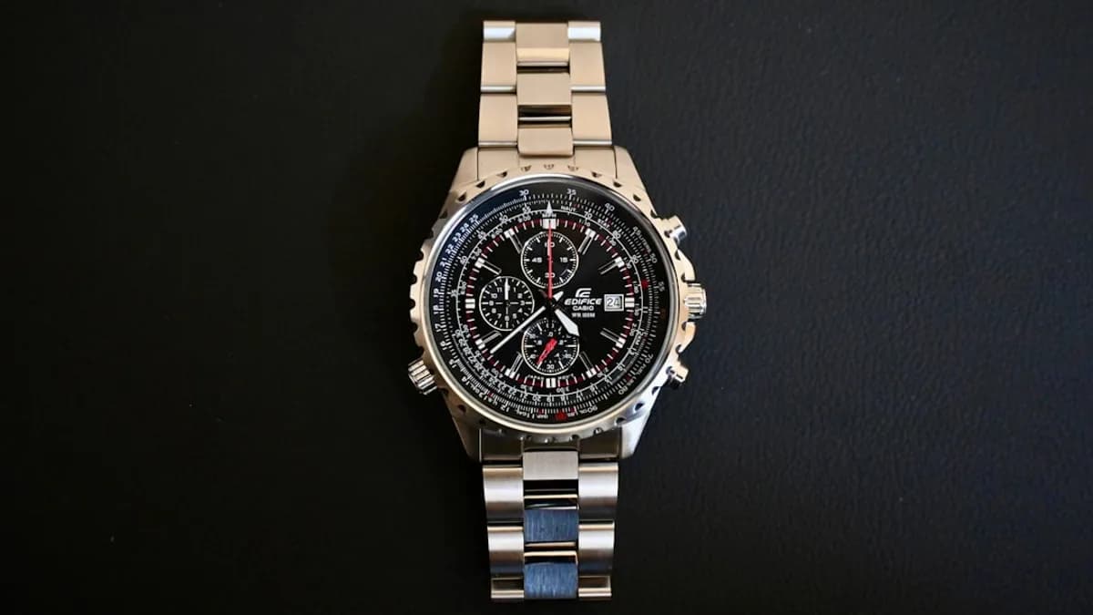 a watch sitting on top of a metal bracelet