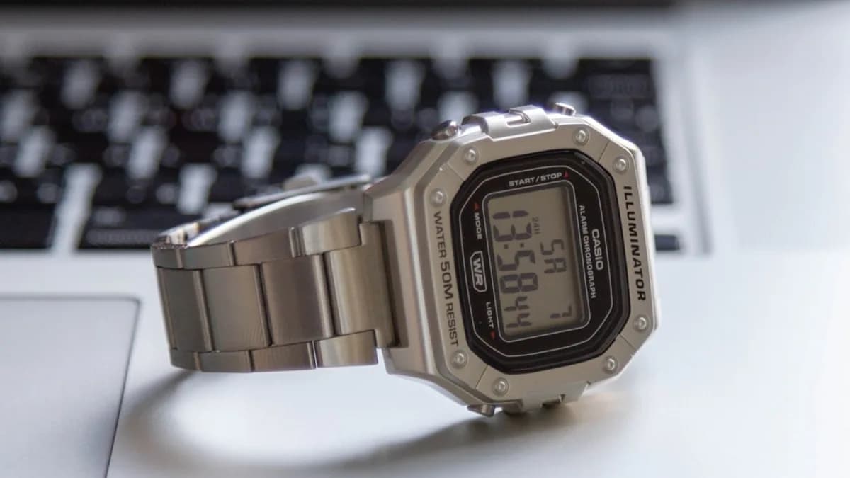 A watch sitting on top of a computer keyboard