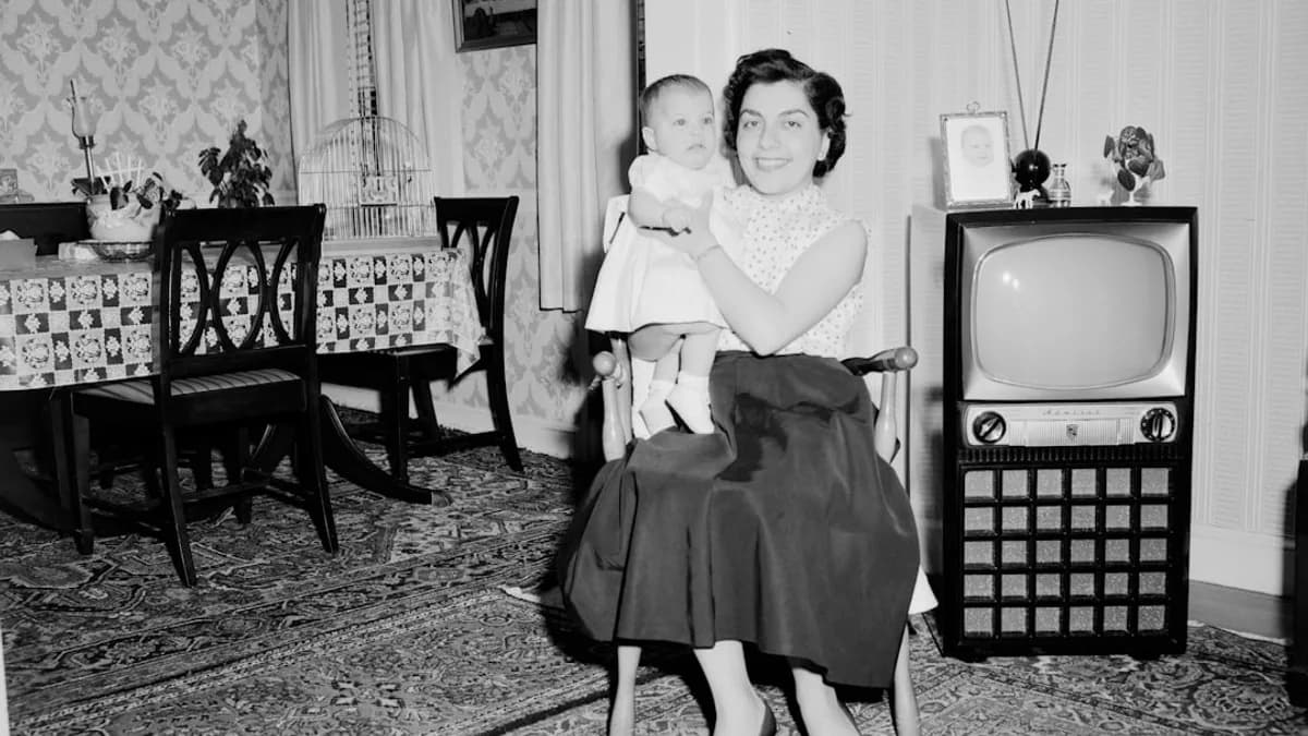 grayscale photo of girl in dress standing on carpet