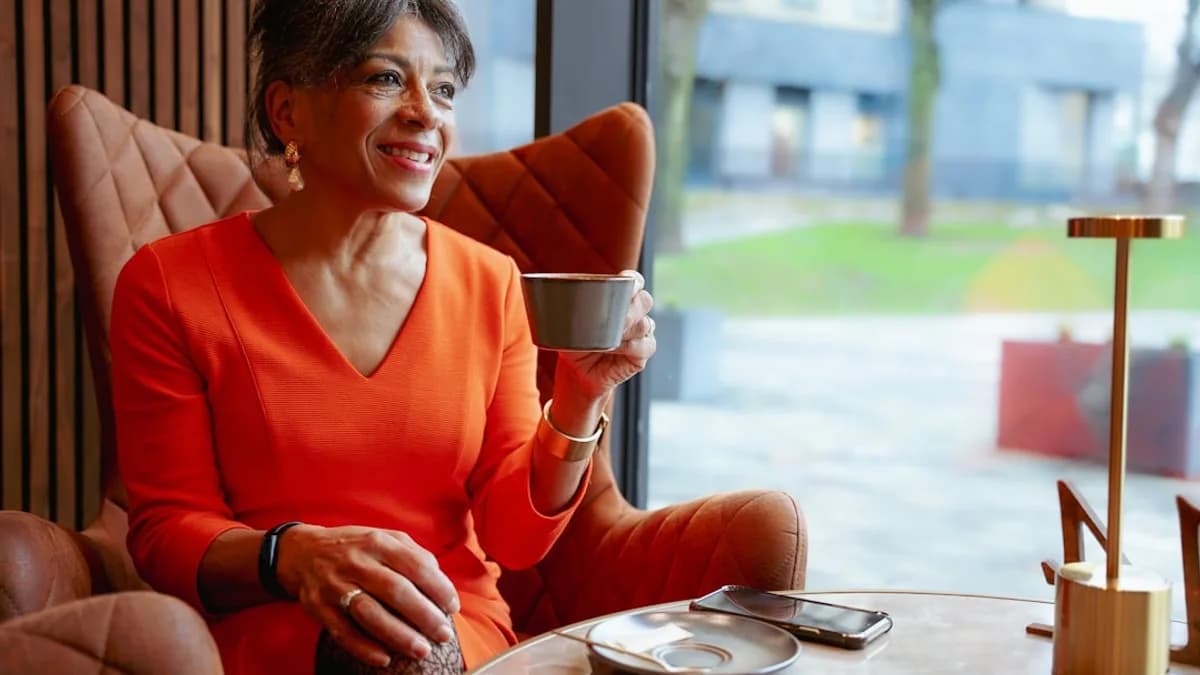 A woman sitting at a table with a cup of coffee