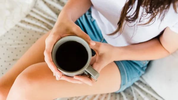 woman holding full ceramic mug