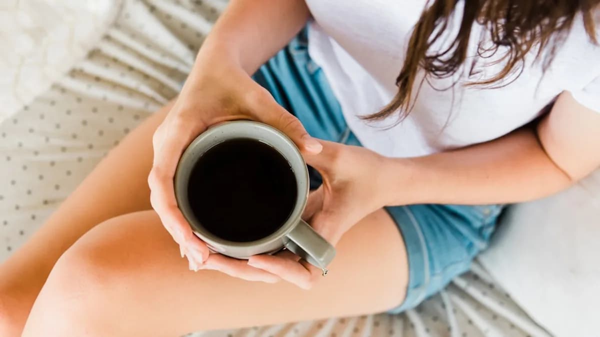 woman holding full ceramic mug