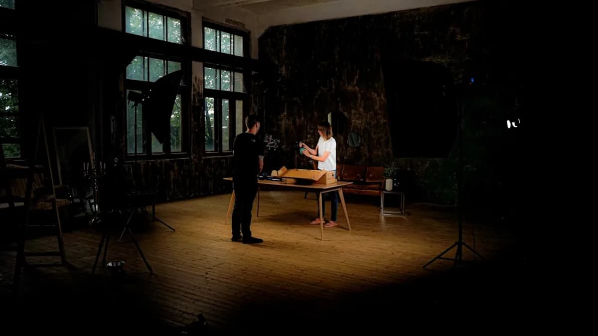 Two people in a dimly lit room with studio lighting.