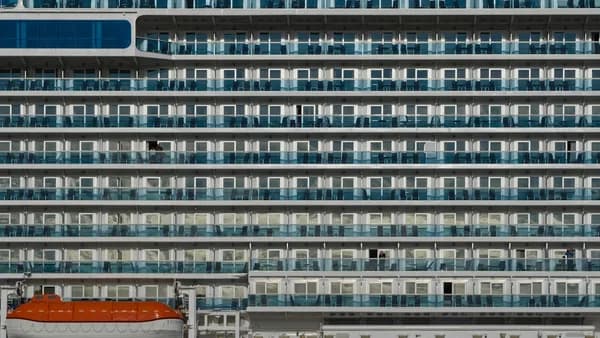 Close-up of a large cruise ship with many balconies.