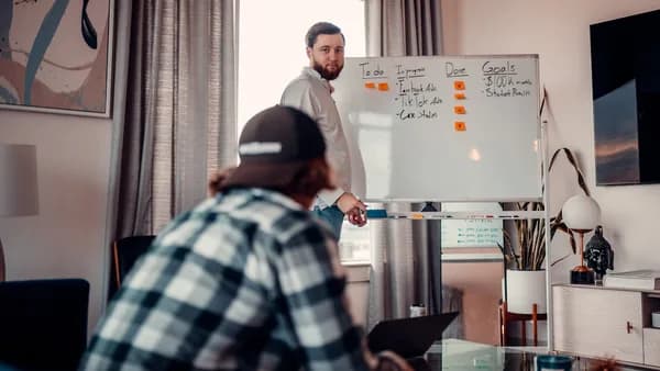 a man standing in front of a whiteboard in a living room