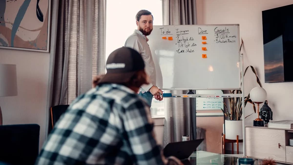 a man standing in front of a whiteboard in a living room