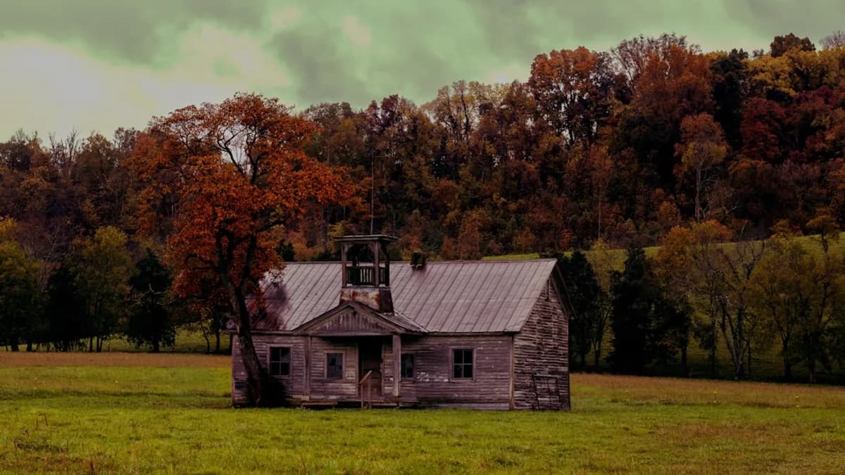 an old house in a field with trees in the background