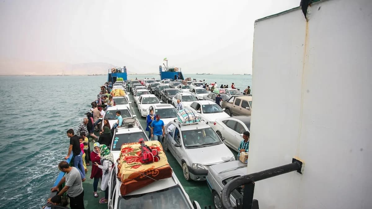 Cars and people on a ferry crossing the ocean.