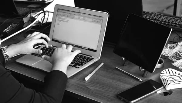 a person sitting at a desk using a laptop computer
