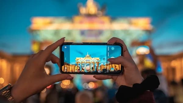 person holding black smartphone taking photo of city buildings during daytime