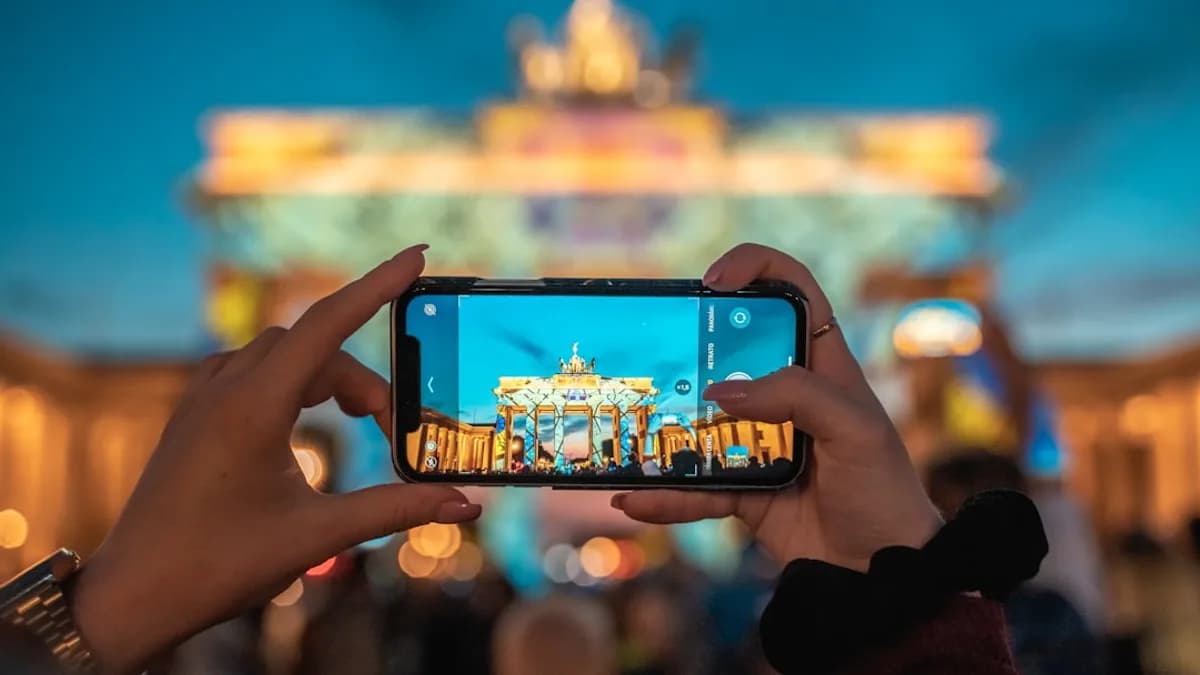person holding black smartphone taking photo of city buildings during daytime