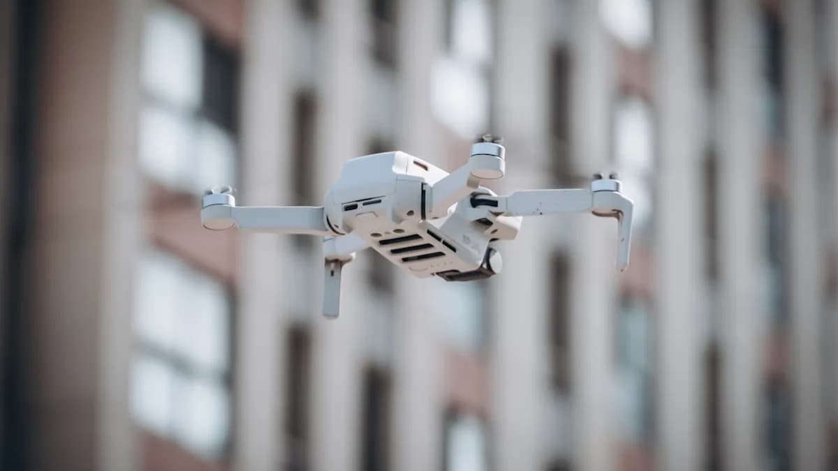 a small white object flying in front of a tall building