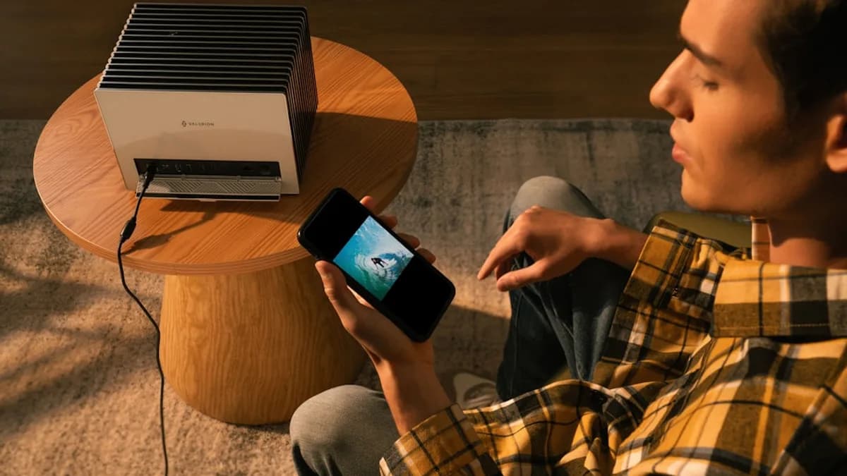 A man uses a phone connected to a projector.