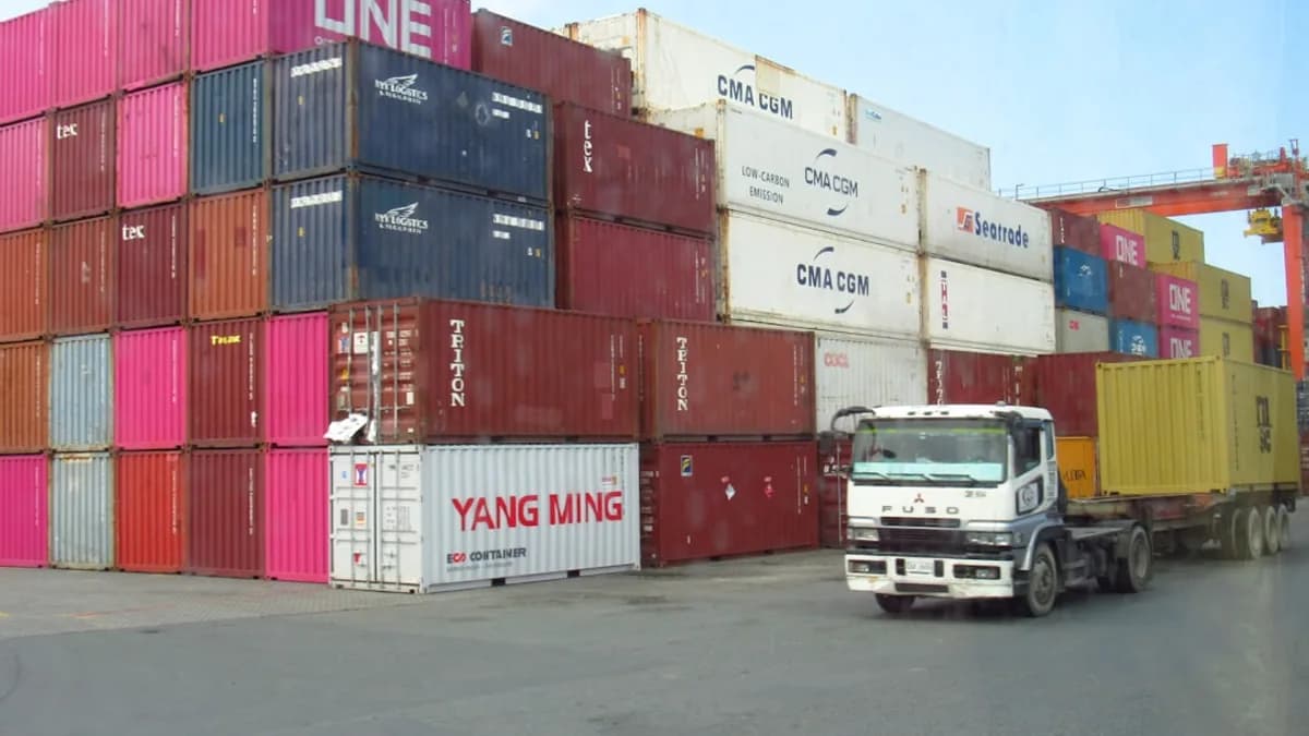 Stacked shipping containers with a truck moving
