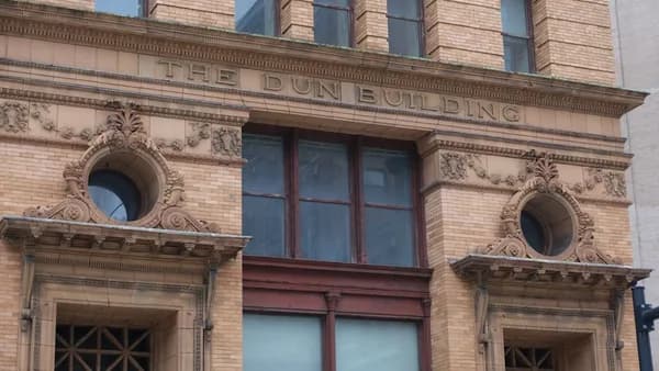 The dun building is displayed on the brick structure.