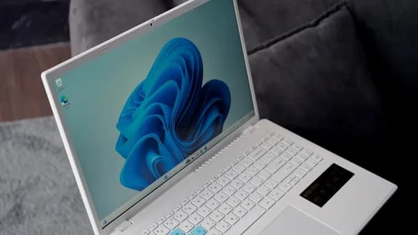 A white laptop with a blue windows 11 wallpaper.