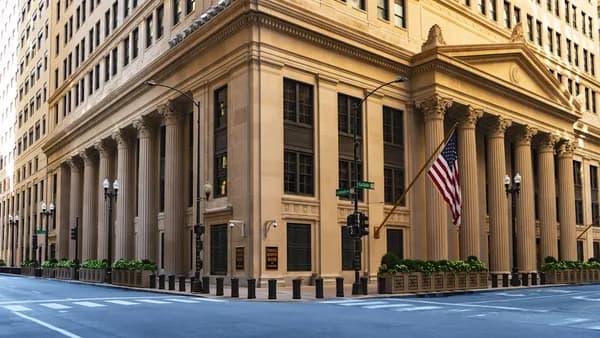 a large building with columns and a flag on the corner